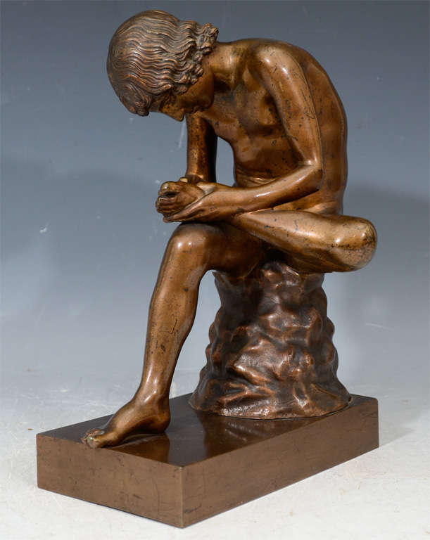 A vintage bronze depicting the classic Greco-Roman sculpture Boy with Thorn (alternately Fedele or Spinario). The piece is after a Hellenistic work depicting a youth sitting on rocks removing a thorn from his foot. There is a Greco-Roman Hellenistic