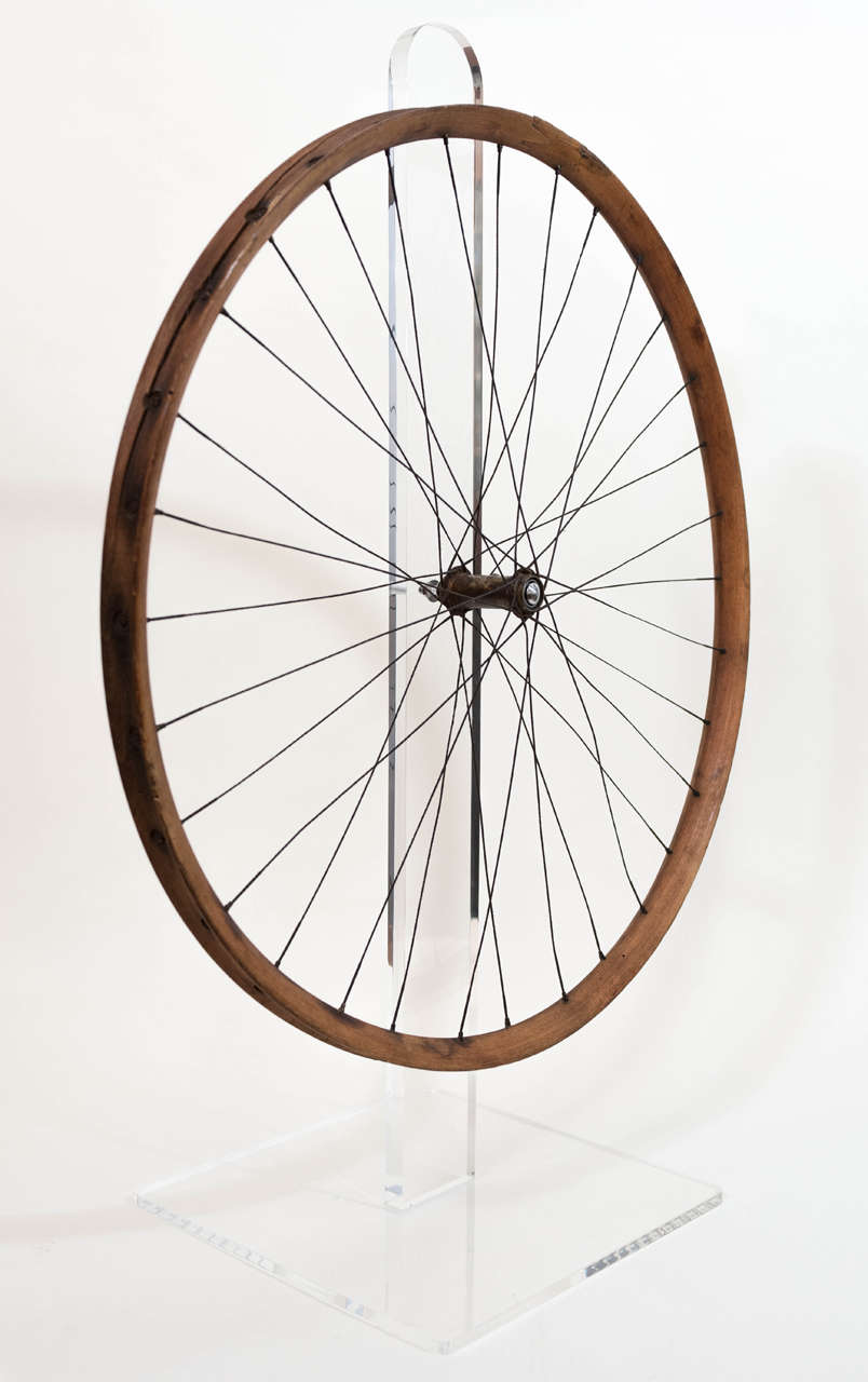 This unique and timeless wood bicycle wheel dates from the mid to late 19th and when mounted on a contemporary custom lucite stand creates a kinetic sculpture ...It spins freely.
It is a perfect complement to a modern or urban decor...or for the