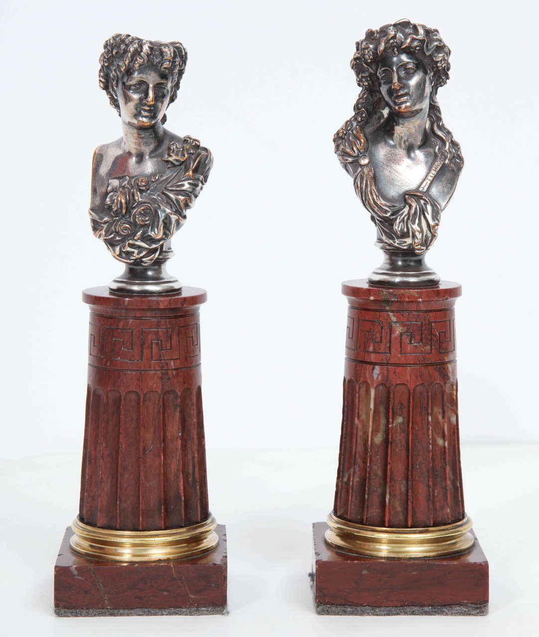 Jean-Baptisite Clesinger (French. 1814-1883): A pair of silvered bronze and rouge marble busts of a Bacchante couple, cast by Marny Hac, 1 Rue de la Paix, Paris. The female bust with ribbon-tied drapery and a sash decorated with roses at her breast,