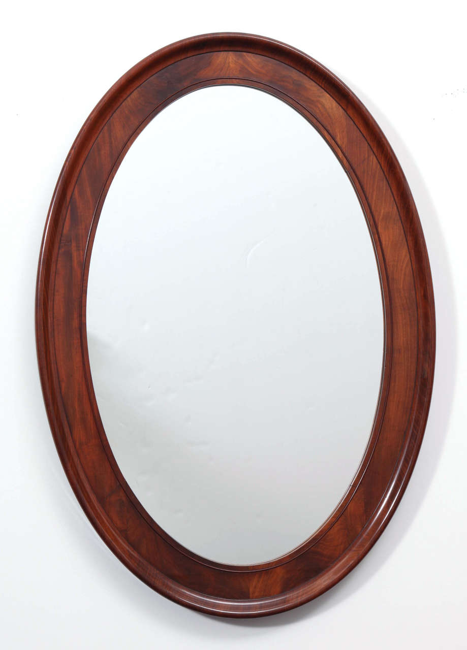 A Danish mahogany oval mirror, Circa 1870s, with a rich mahogany molded frame. Mirror plate later date.