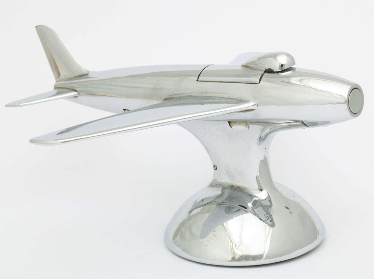 A Dunhill 'Jet Plane' Lighter that is modeled after the famous American F-86 Sabre transonic jet fighter aircraft. This aircraftset its first official world speed record of 570mph (920km/h) in September 1948. This table lighter first appeared in the