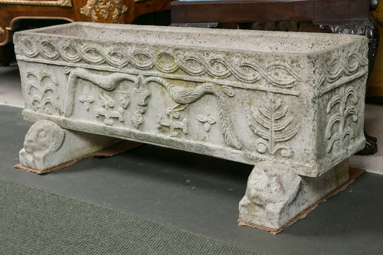 A pair of carved stone aggregate, continental neoclassical style troughs/planters atop reclining lion feet.
