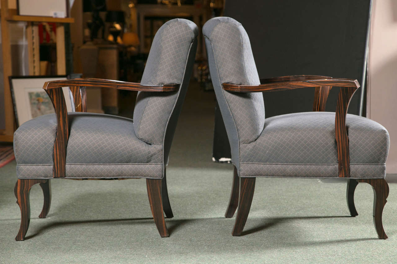 A pair of Art Deco upholstered seat & back armchairs with stylish accent arms and legs in Palisander wood.