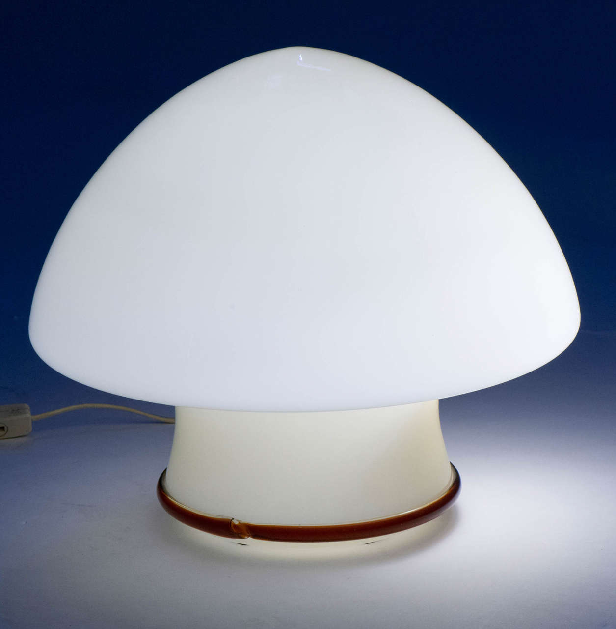 Murano glass table light.
Cream colored glass with crimson colored band on lower base,
Italy, circa 1965
Measures: 40 cm high x 42 cm diameter.