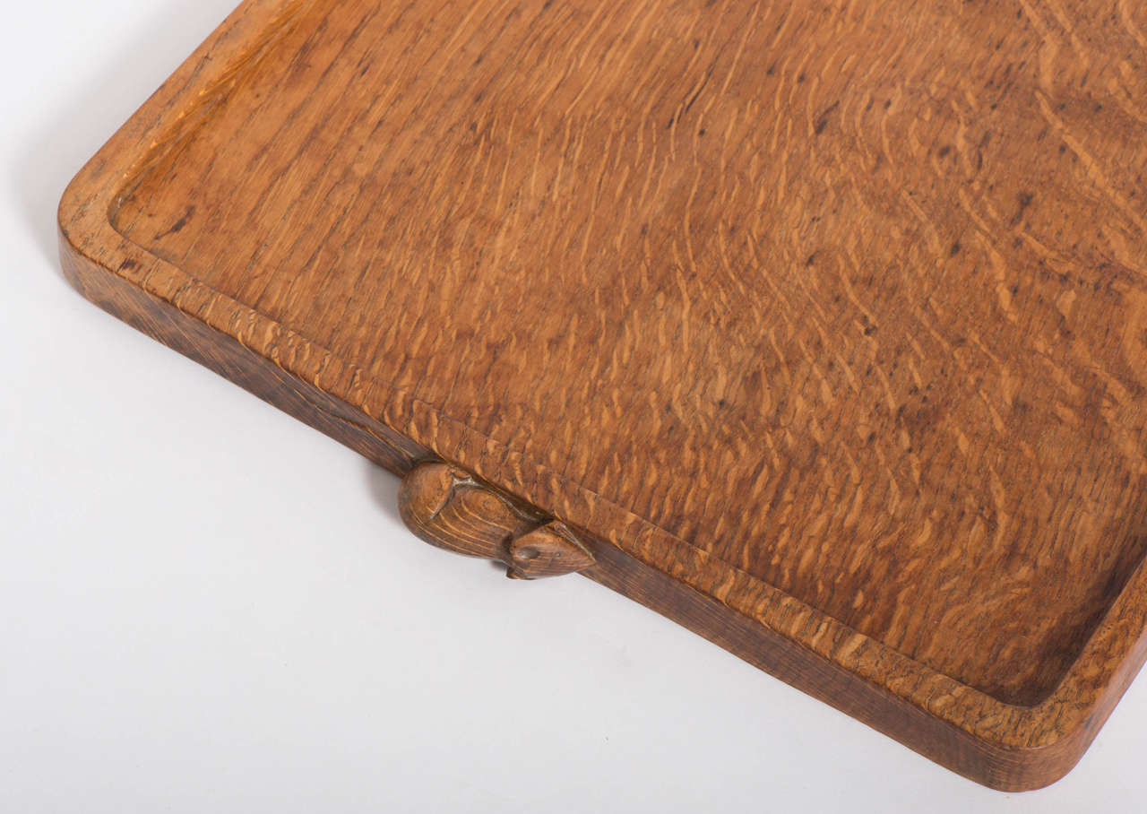 A Robert Mouseman Thompson oak rectangular tray, with two carved mice handles.
Adzed decoration.
England, circa 1950.
Measures: 2.5 cm high x 49 cm wide x 34 cm deep.