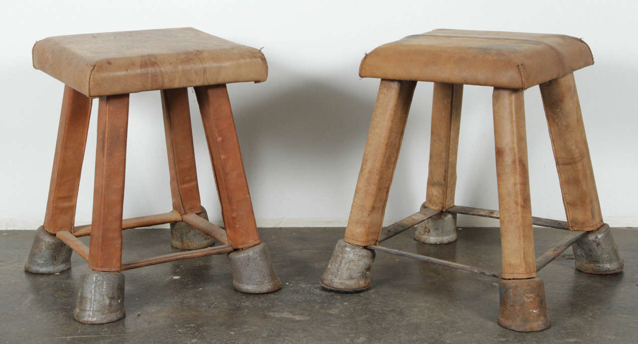 Pair of vintage leather gym stools with iron feet. Leather has unique worn patina. Made in France, circa 1940s