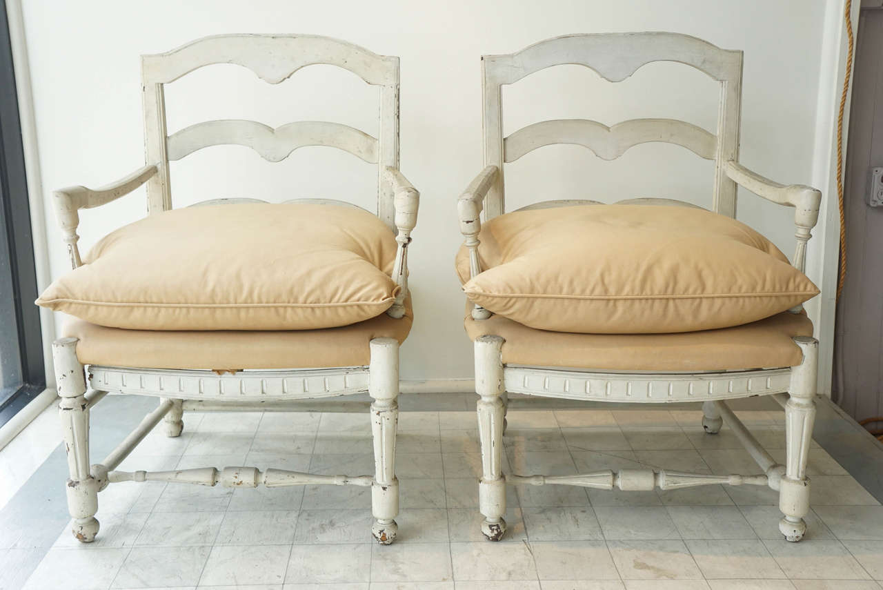 pair of french country fauteuil arm chairs - pinned construction - generous seating - shabby white painted surface - 'as found' upholstery