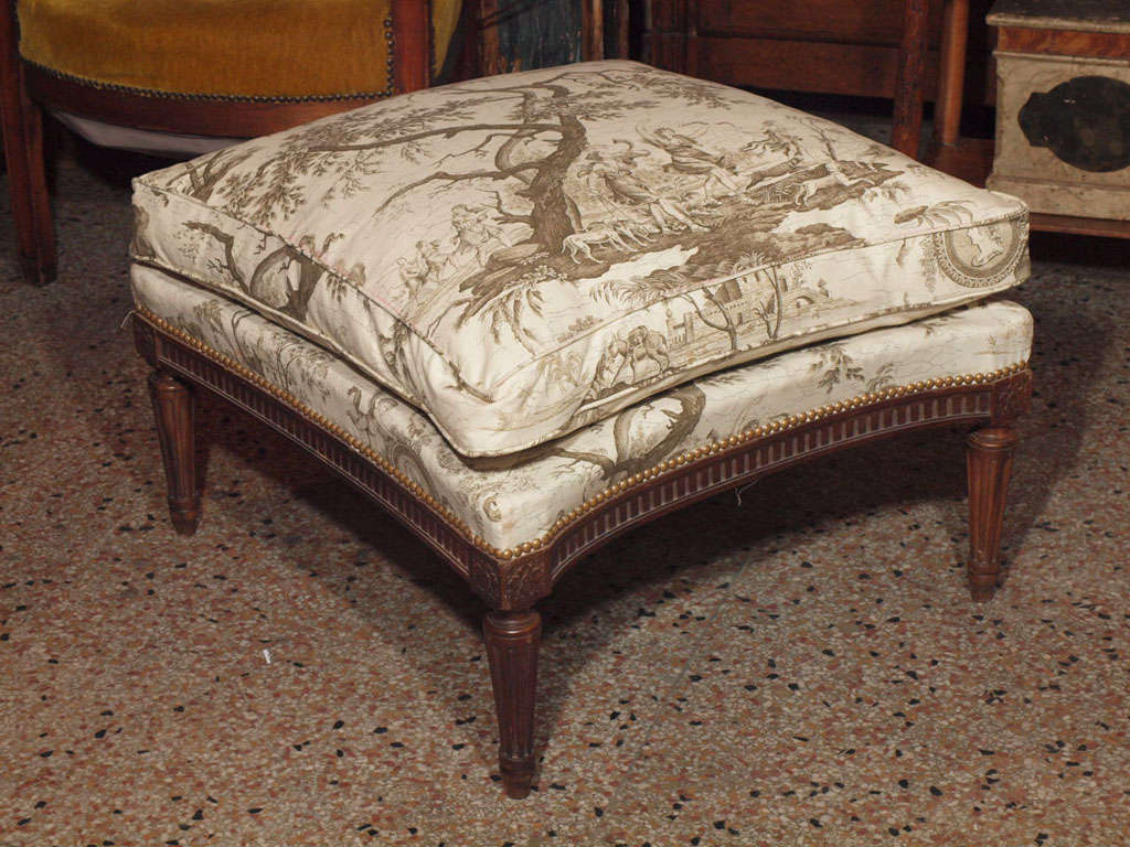 French Directoire Style stool covered in cream and brown toile upholstery affixed to the frame with brass tacks.<br />
Wood fluted skirt and legs with rosettes on each corner.