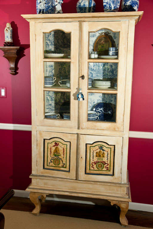 PAINTED  FOUR  DOOR CABINET-  TOP  INTERIOR  LINES  WITH  TOILE FABRIC- MULLION GLASS DOORS ON  TOP-- CREAM COLOR