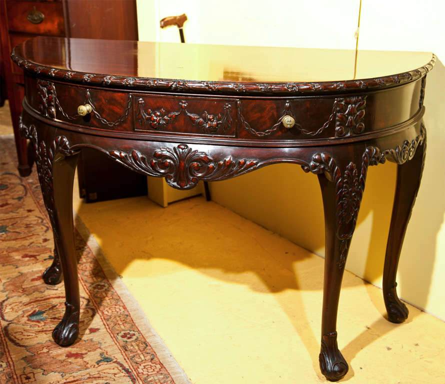 A fine English Georgian style demilune console table, the half-moon top over a nicely-decorated frieze fitted with a single drawer, atop a scalloped apron standing on four cabriole legs.