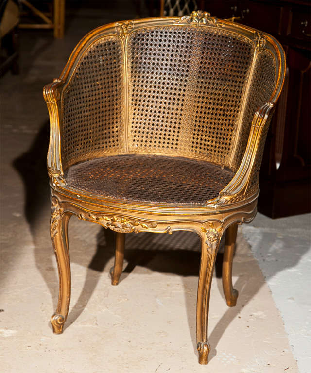 Pair of French Louis XIV style bergere chairs, circa 1940s, overall painted and parcel-gilt, caned back and seat, raised on cabriole legs. By Maison Jansen.