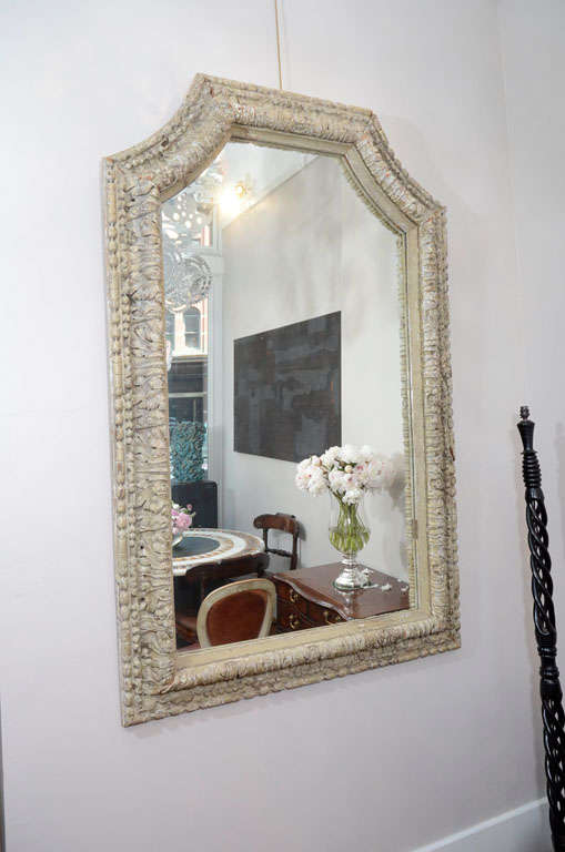The frame with a repeating bead and reel and acanthus carved pattern. The frame retaining gesso and traces of original grey paint. The frame size altered at a later date.