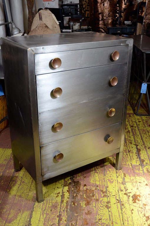 Pair metal dressers designed by Norman Bel Geddes made for Simmons Furniture, with four drawers, round brass knobs and square legs.