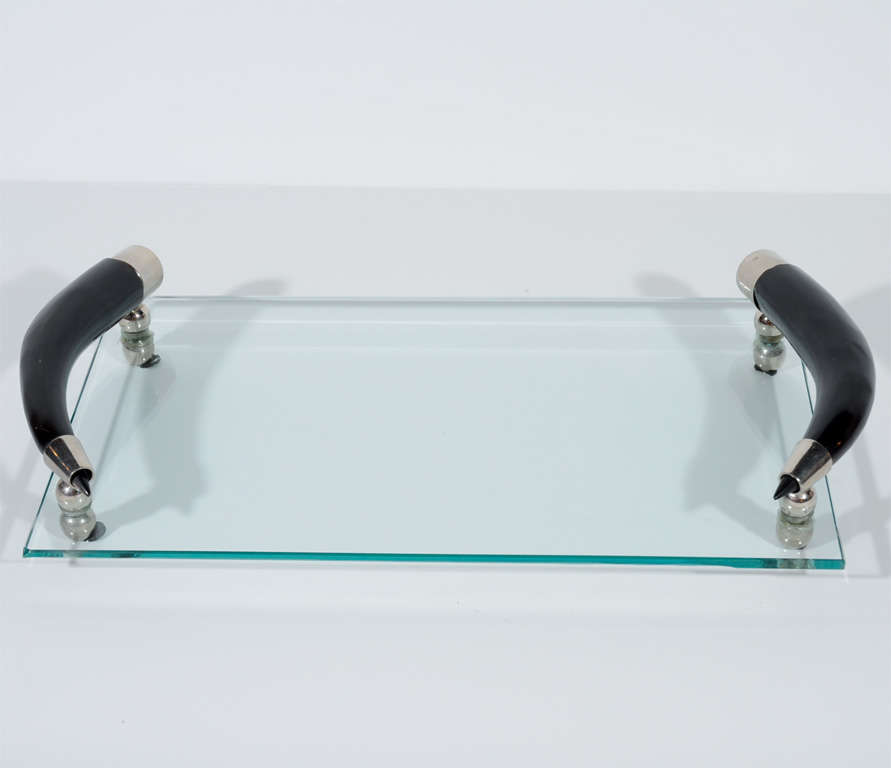 Modern glass bar tray perfect for serving or<br />
as a decorative object for the bedroom or<br />
a powder room.  The tray has stylized horn<br />
handles with nickel fittings and ball feet.