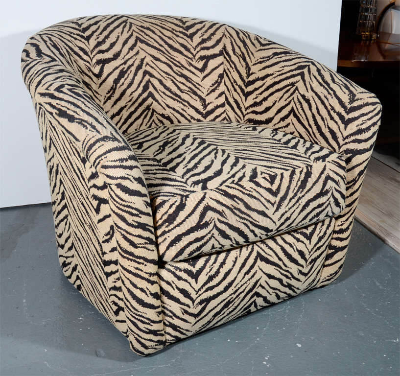 Modern lounge chairs with stylized textured zebra print upholstery in hues of oatmeal and brown.  Chairs have barrel back design and channel tufted details as well as swivel base.