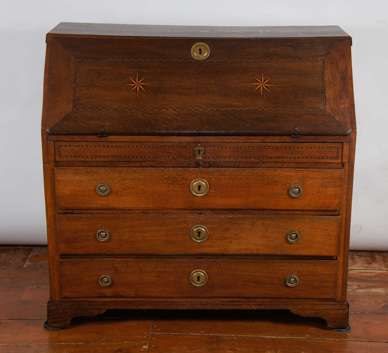 Wonderful Friesian solid oak bureau having dual compass star and string-band inlaid fall front enclosing a fitted inlaid interior of pigeon-holes and drawers with a secret drawer enclosed within a slide and carved bone inscription plaque and pulls,
