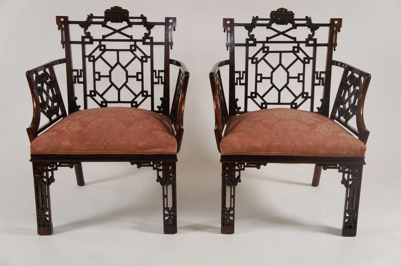 Highly important pair of George III style mahogany trellis back armchairs having acanthus leaf carved crestings above pierced 'Chinese' fretwork backs with conforming trellis filled arms, the seats upholstered and on pierced fretwork square front