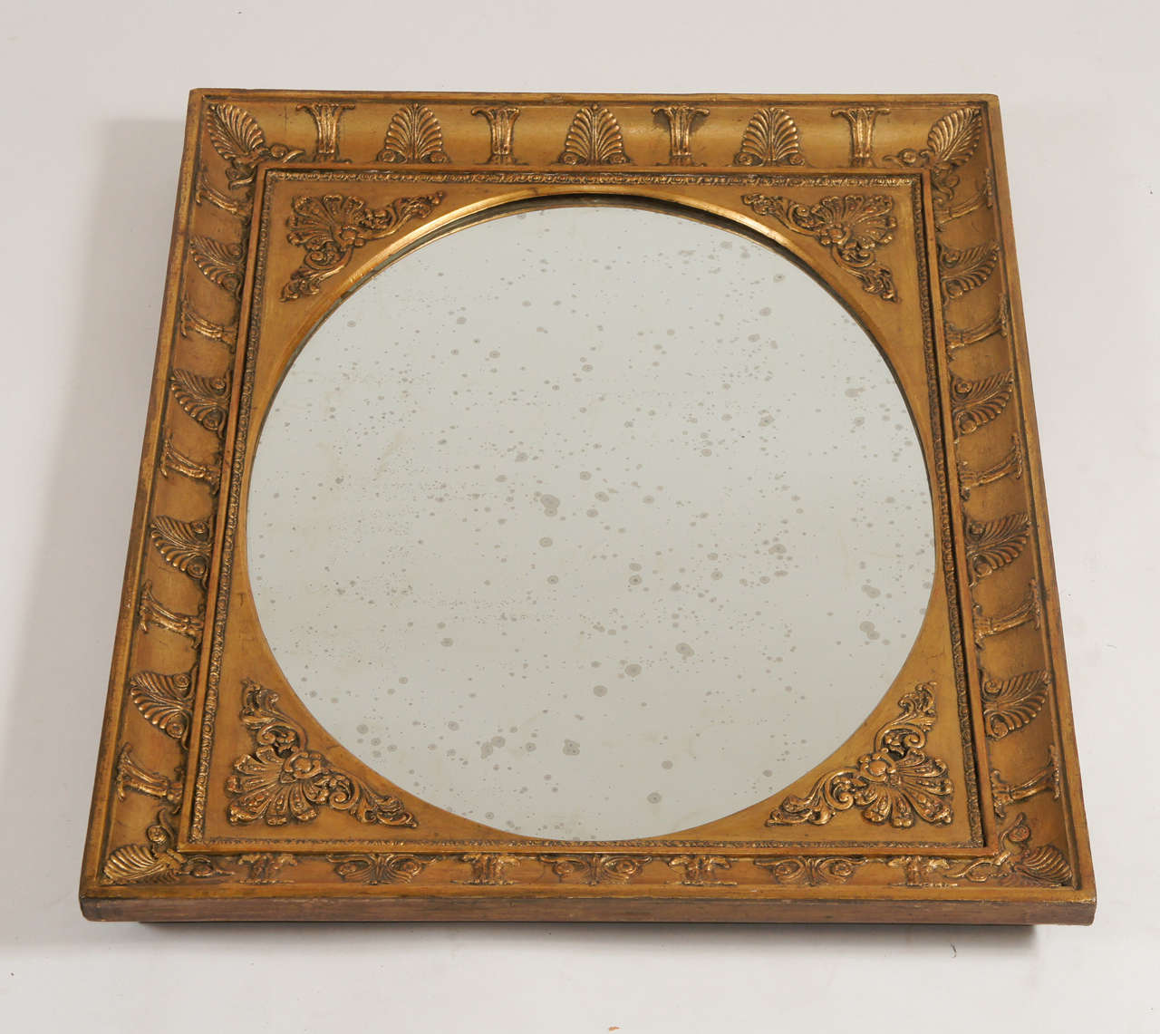 Beautiful French Charles X period giltwood mirror or looking glass of rectangular form having central oval mirror glass reserve with fillet having corner foliate motifs and frame with alternating palmette and gathered stalk design.