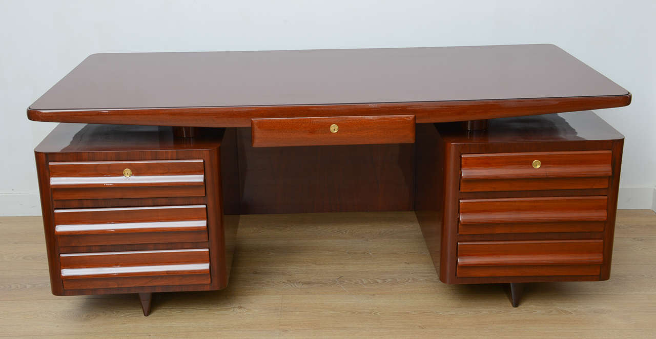Rare 1950s rosewood executive desk with inset burgundy glass top floating on seven-drawer double pedestal. Restored to perfection.