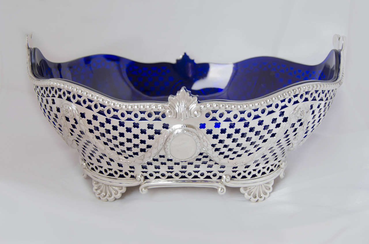 Gran jardinera victoriana antigua de plata de ley con forro de cristal azul. El plato está perforado por todas partes, tiene un borde de cuentas y se apoya en cuatro patas de concha.
