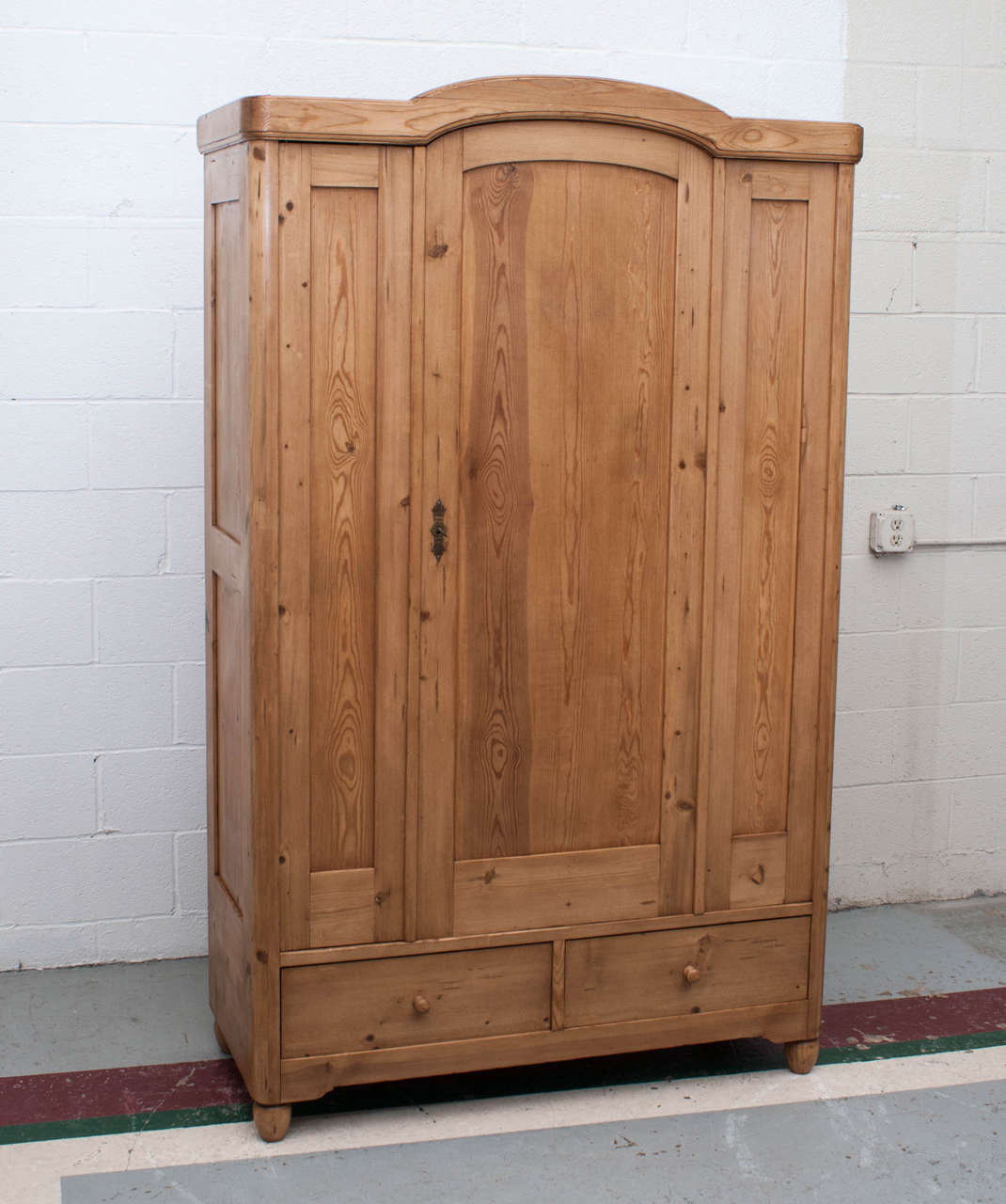 An unusual two door bonnet top pine armoire masquerading as a three door; the right hand and centre 