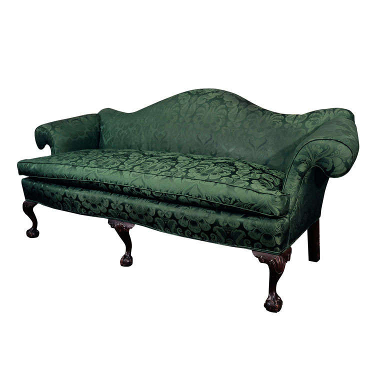 A Carved Mahogany and Upholstered Camelback Sofa For Sale
