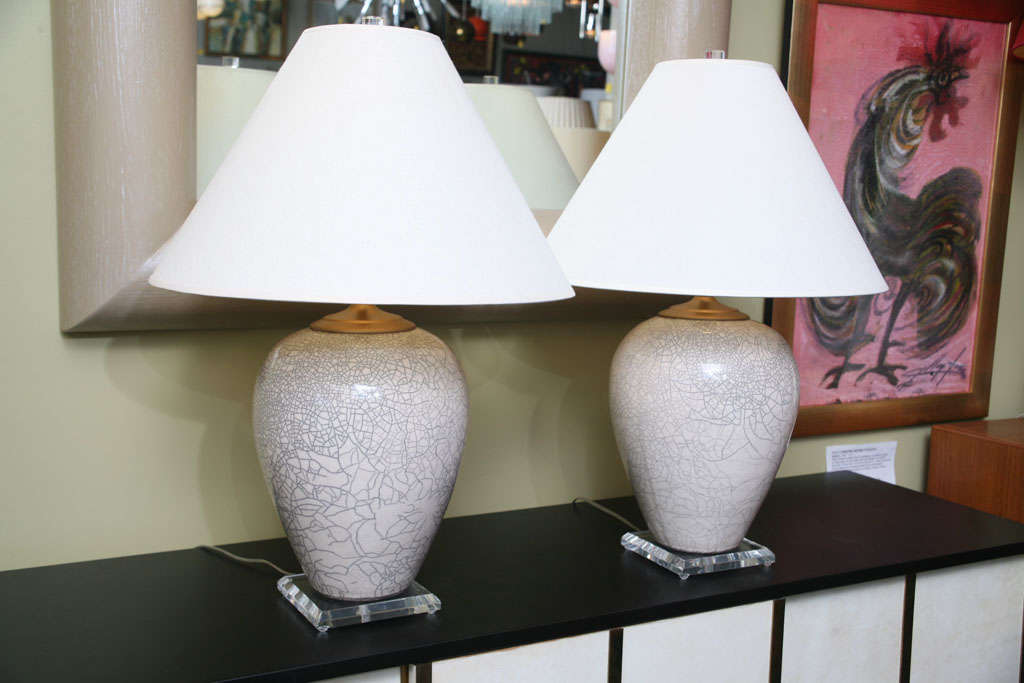 SOLD JAN 2011 Elegant and sophisticated Raku white crackle vases by master potter Marc Ward mounted as table lamps with lucite socle bases and finials and gilt metal cap lids.  Beautiful white glaze with intricate carbon infused crackle.  Modern
