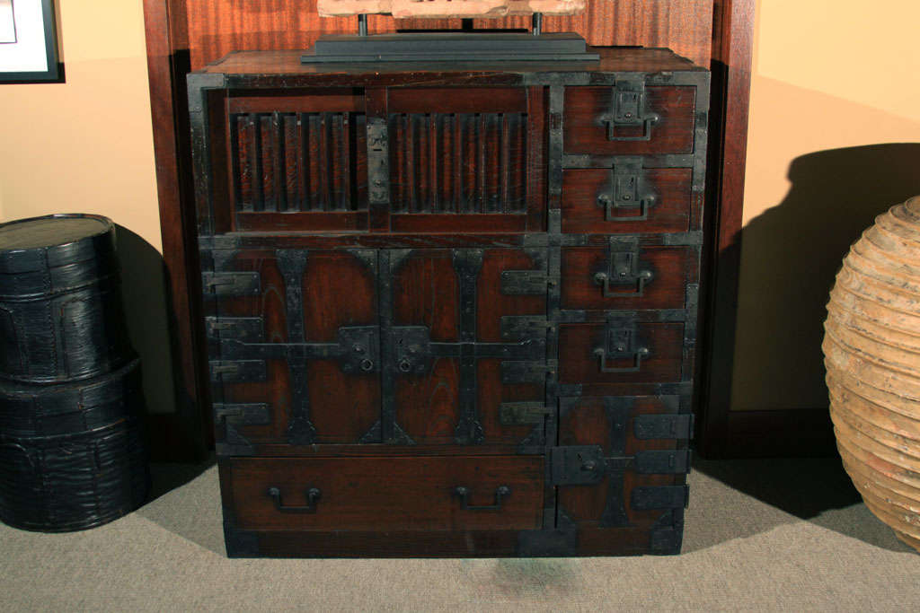 Japanese choba dansu (office chest) of unusual dimensions. The single section tansu constructed of sugi (cypress) wood with keyaki (zelkova) wood façade. The top left hand corner with slatted sliding doors and a run of five stacked doors on the