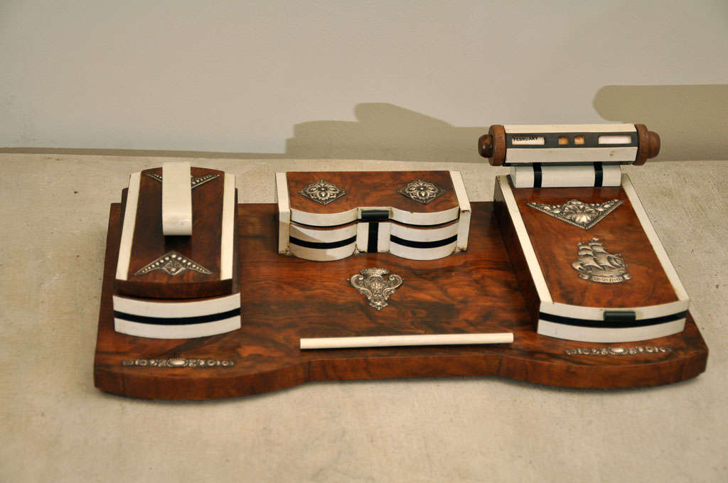 Elaborately detailed art deco desk set. Burled wood with cast metal accents and an operational month, day and date reader.