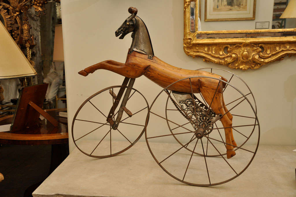 RARE AND UNIQUE WOOD HORSE ON IRON WHEELED TRICYCLE WITH EXCEPTIONAL IRON CASTINGS.