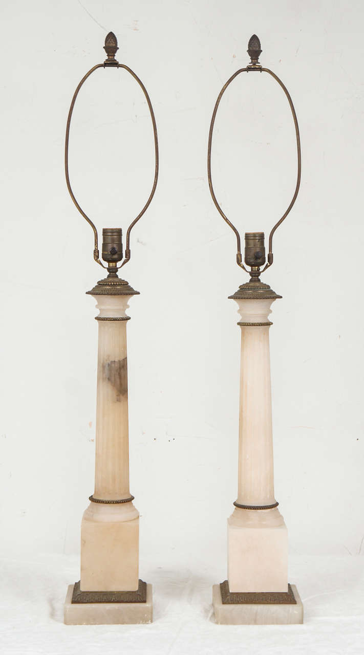 Pair of fluted column lamps with ormolu trim.  Classic slender shape enhances any traditional or contemporary decor.
Measurements are for each lamp and includes the socket. The harp is an additional 12