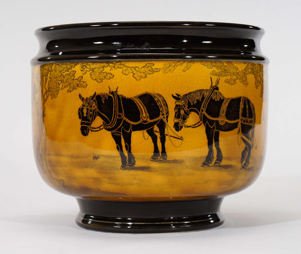 Impressively large Arts and Crafts amber-yellow jardiniere decorated with striking black, contrasted work work horses that encircle the body of the vessel. The pattern is named 