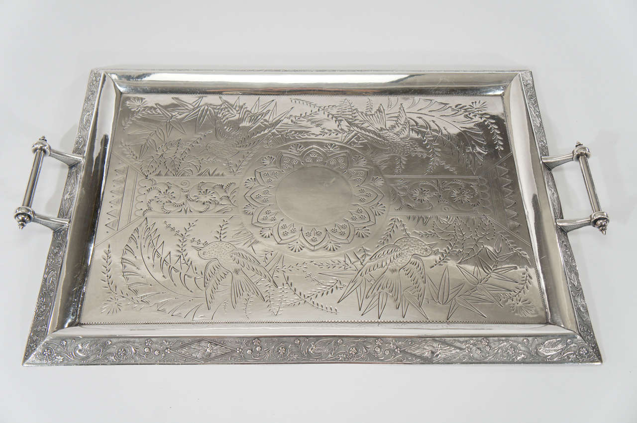 A superb example of an American Aesthetic Movement decorated rectangular tray with finely engraved birds, flora and fauna. The slanted border has tightly chased and detailed engraving and the center is more openly decorated with birds and leafy,