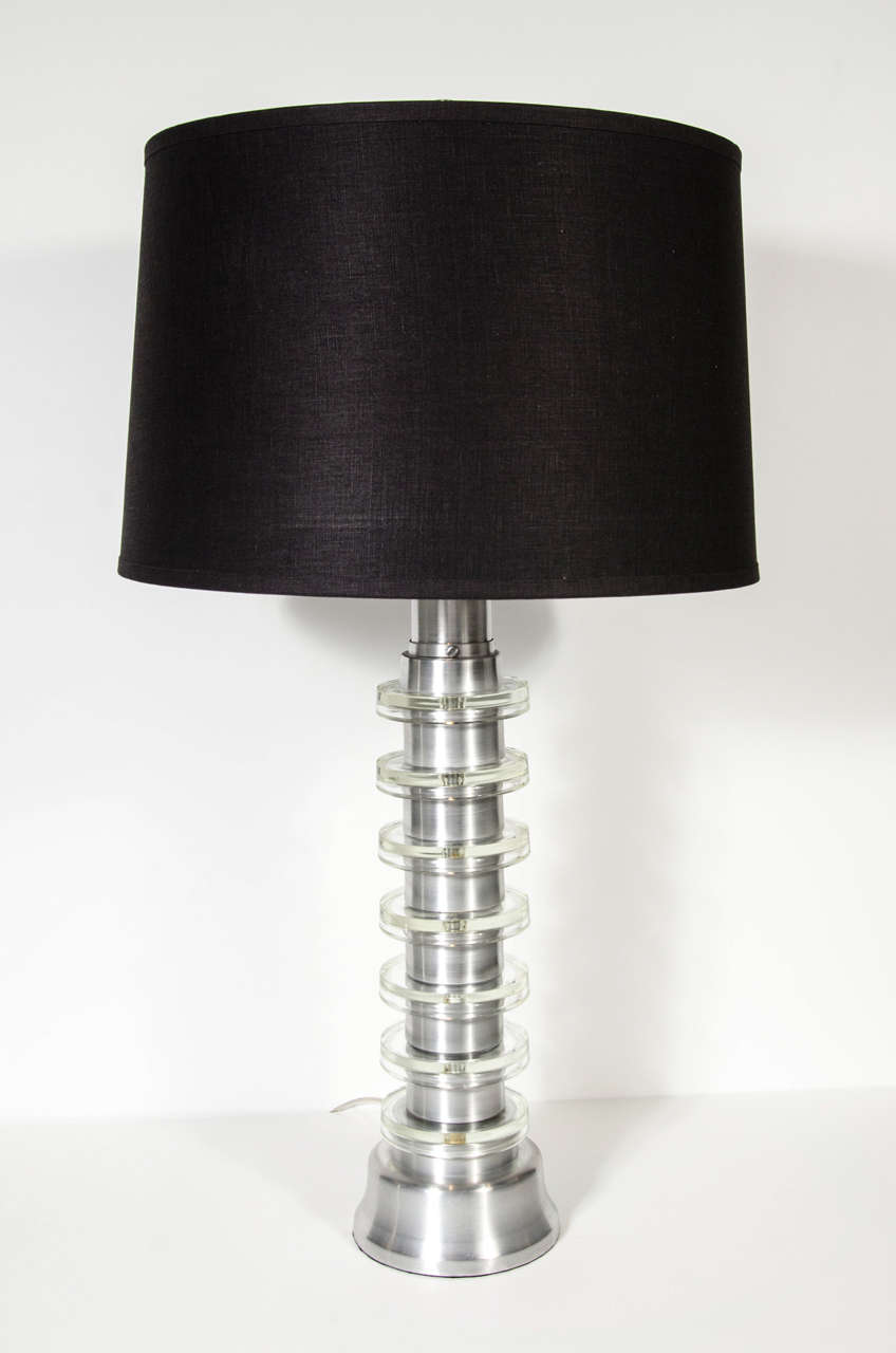 These stunning lamps are made of Brushed aluminum with glass disk details. They epitomize the Machine Age and Industrial Eras movements influence on Art Deco.They have been newly rewired and are fitted with custom shades as well.