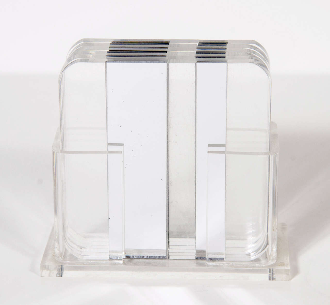 This lucite coater set features a modernist coaster holder fitted with 6 coasters with accent silver bands with a rounded corner design.