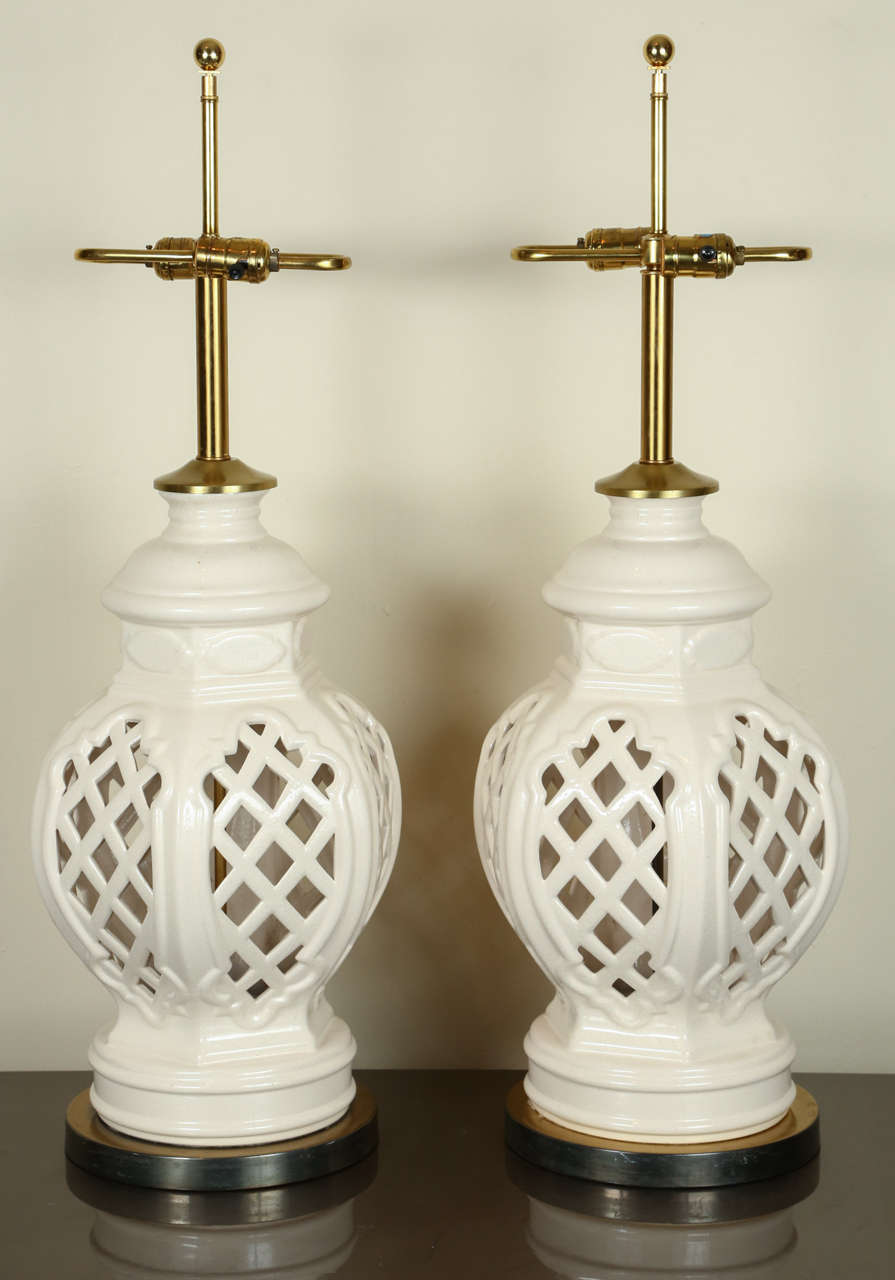 Pair of fine glazed ceramic lamps with a pierced basket weave design.  They are newly rewired and retain their original brass S-shaped double clusters.