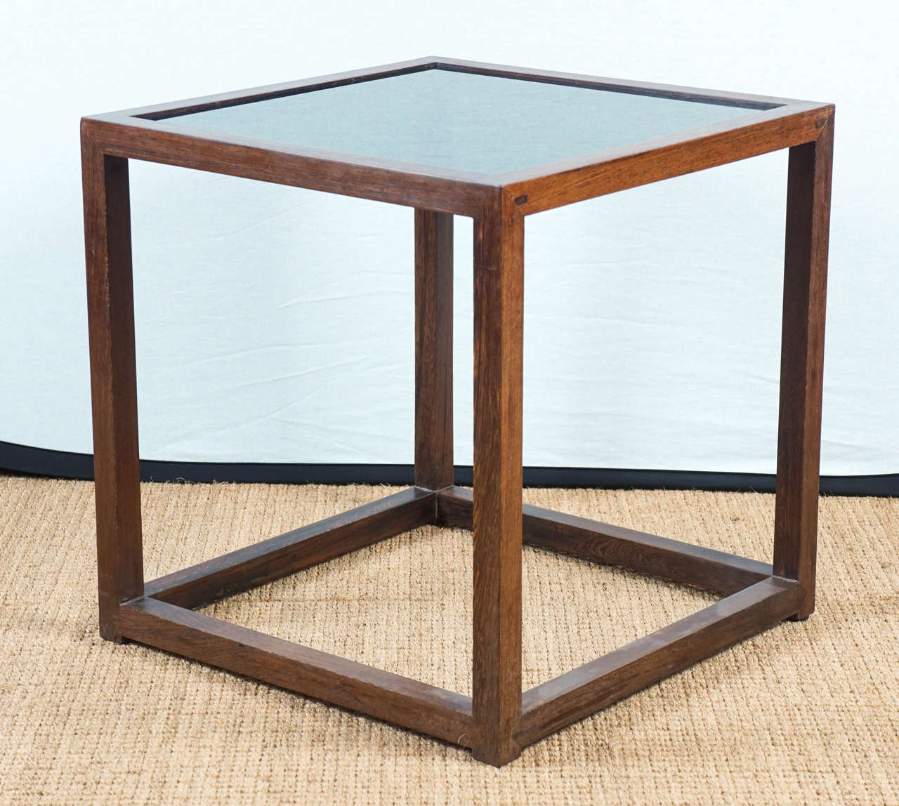 vintage, cube style side table, with smoky glass top insert, supported by square shaped legs, with mitered corners and very slight feet.