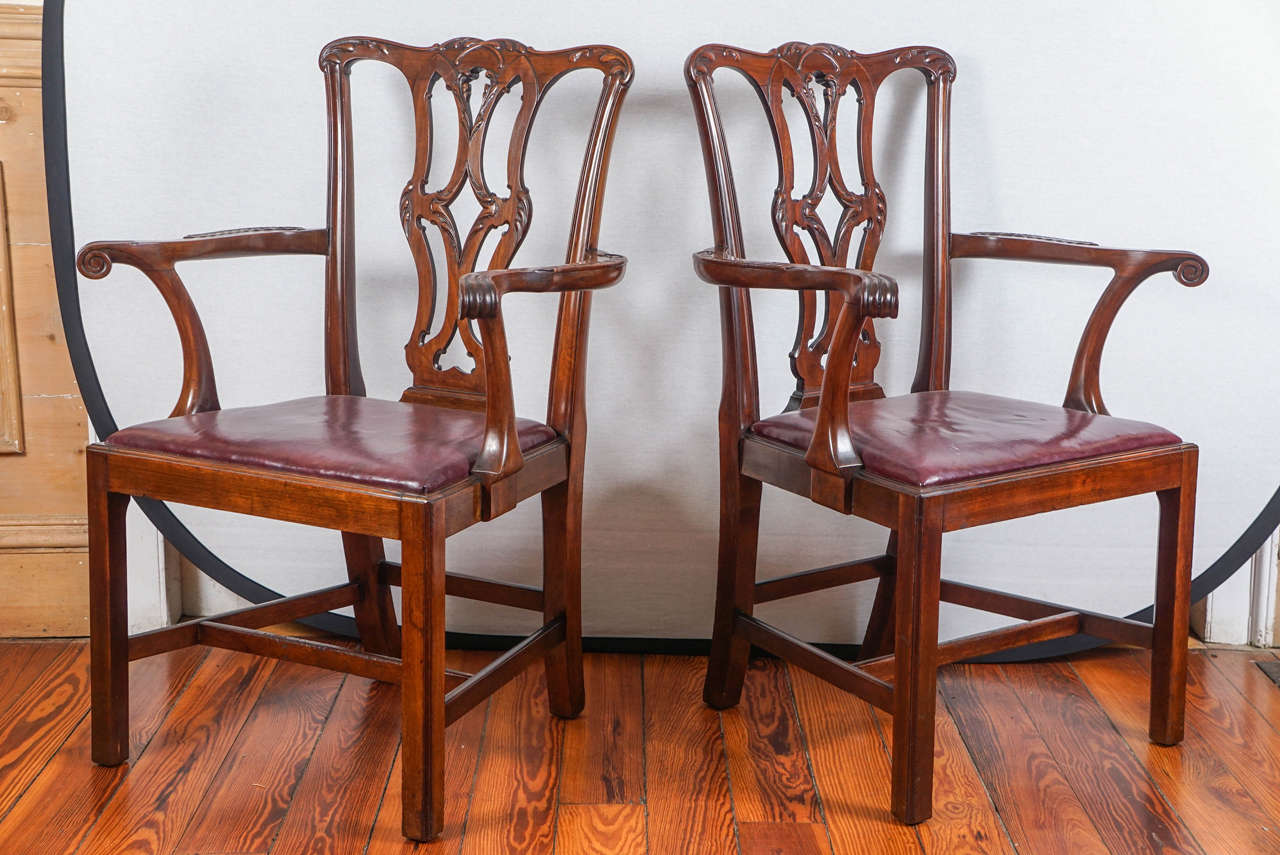Pair of 19th century Chippendale-style leather upholstered armchairs.
Mahogany. Open carved splat. Label on the underside of chairs "Made by Cowtan & Tout, New York and London." Dark red leather seats.