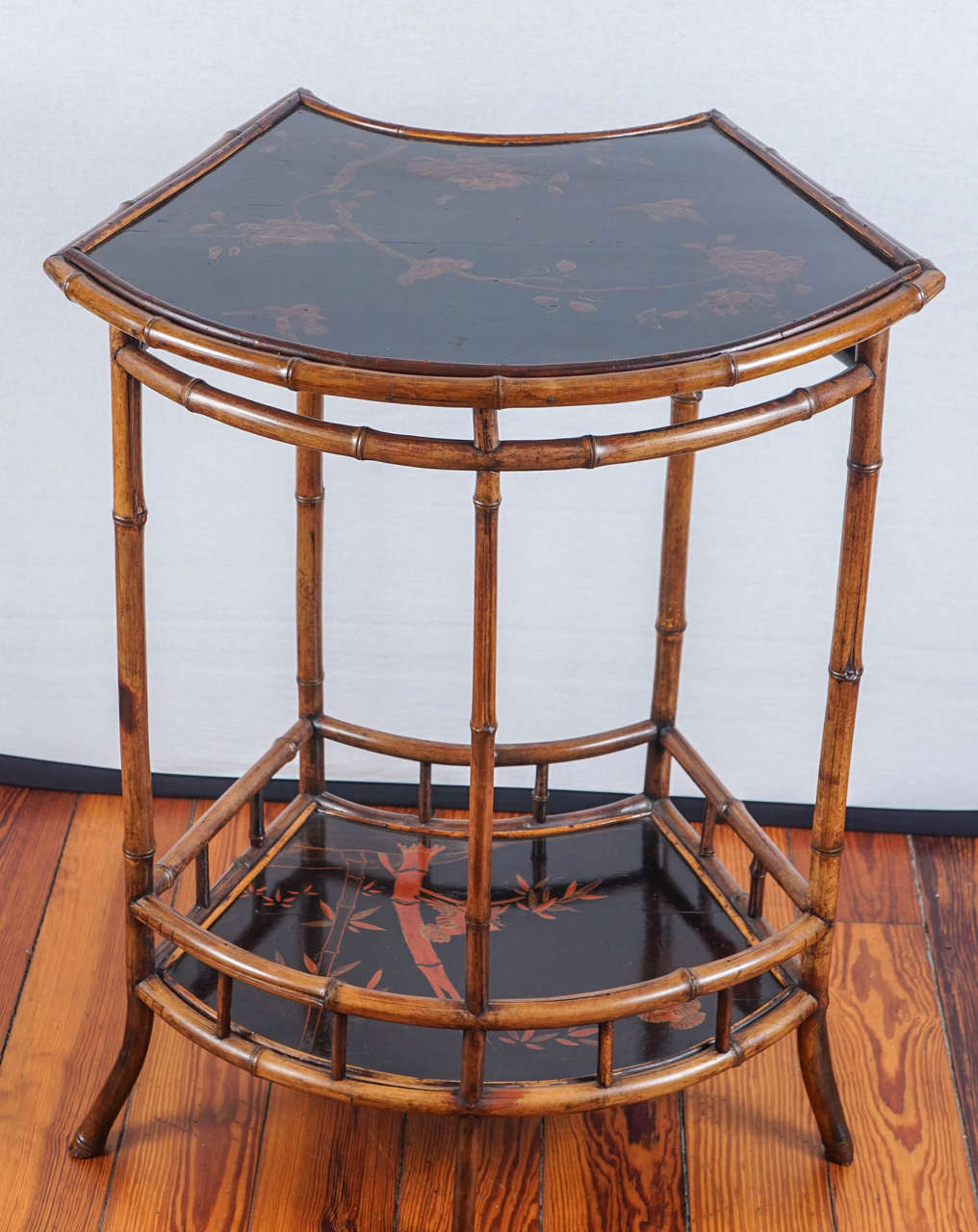 Edwardian-style bamboo and Japanese lacquer two-tier concave front
table. Red flowering tree decoration on both tiers.  Probably created for
the Anglo-Indian market.