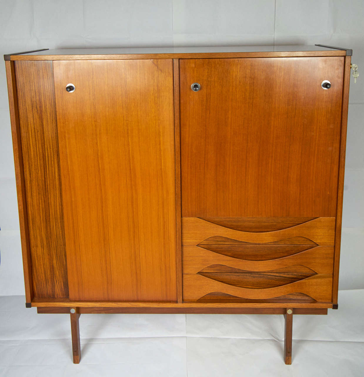 Teak and exotic wood cabinet, tree drawer and two doors with shelves inside.
Mid century Italy 1950's