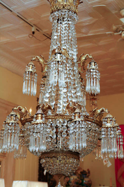 A French Empire style grand salon chandelier with fifteen bronze swans holding light pendants around the outside on two tiers. And having twelve lights on the interior.