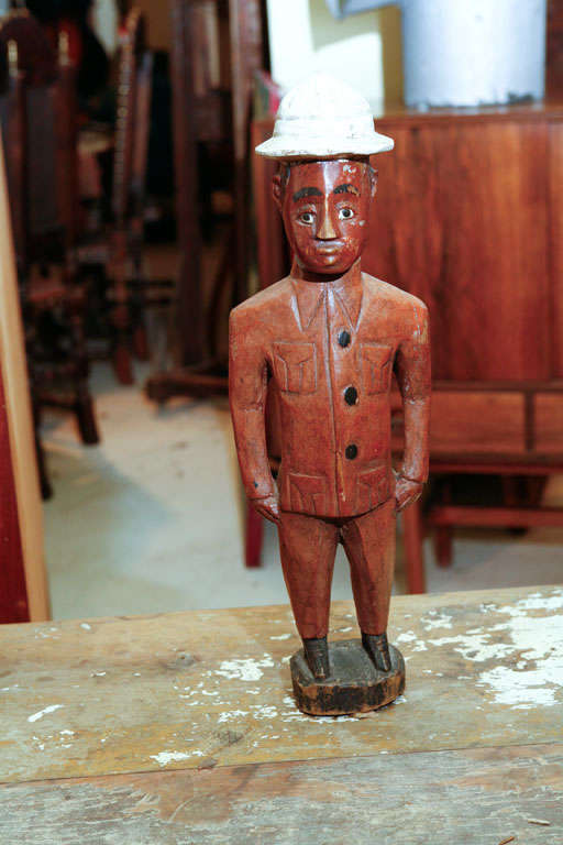 Wood carving of an colonial African wearing a pith helmet
