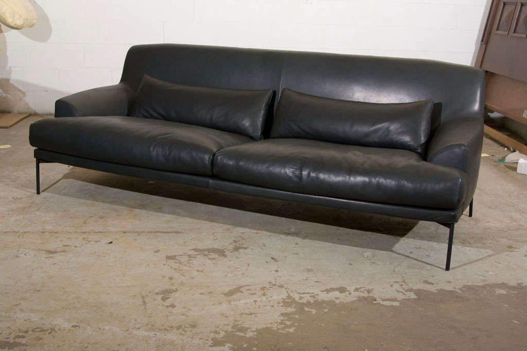 THIS GENEROUSLY SIZED SOFE OF PART OF A SUITE OF SEATING. UPHOLSTERED IN BLACK LEATHER AND HAS SLIM BLACK METAL LEGS. DPWN LUMBAR CUSHIONS. DESIGNED BY CLAESSON-KOIVISTO-RUNE AND MANUFACTURED IN ITALY BY TACCHINI. TWO SOFAS ARE AVAILABLE- BOTH ARE