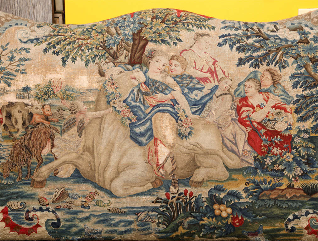 An Italian walnut Classical sofa with hand-carved frame, the triple arched back and seat upholstered in 18th Century needlework with detailed petit-point depicting the celebration of the harvest of wine, trimmed with nail heads. Needlework is