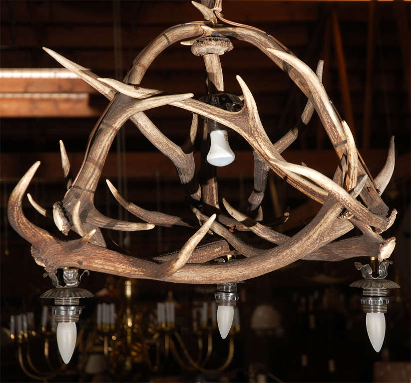 A very nice deer horn light fixture, in a convenient size having four down lights, probably from Germany, circa 1910. We offer this chandelier as well as over 150 other antique lighting elements, all on display and ready to be installed. 
