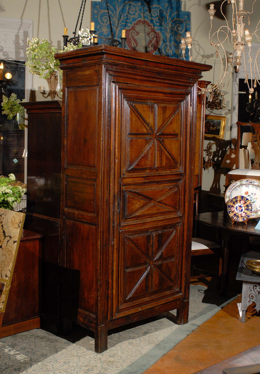 A French 18th century fruitwood bonnetiere armoire with carved doors. Originally created in the Normandy area of France, bonnetieres started to spread throughout France during the 18th century. Made to receive bonnets and ‘coiffes’ (the traditional