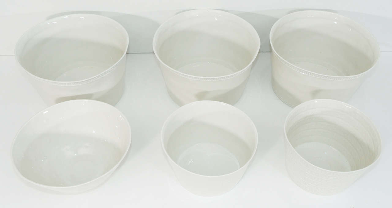 This charming collection of white porcelain is handmade in Limoges, France. There are three large bowls (