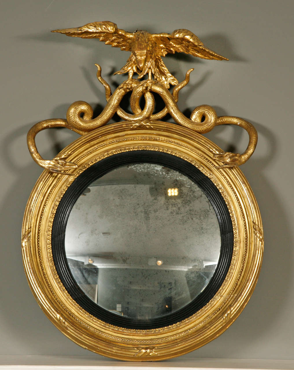 with eagle and intertwined serpent cresting above a well patinated plate within a reeded slip.