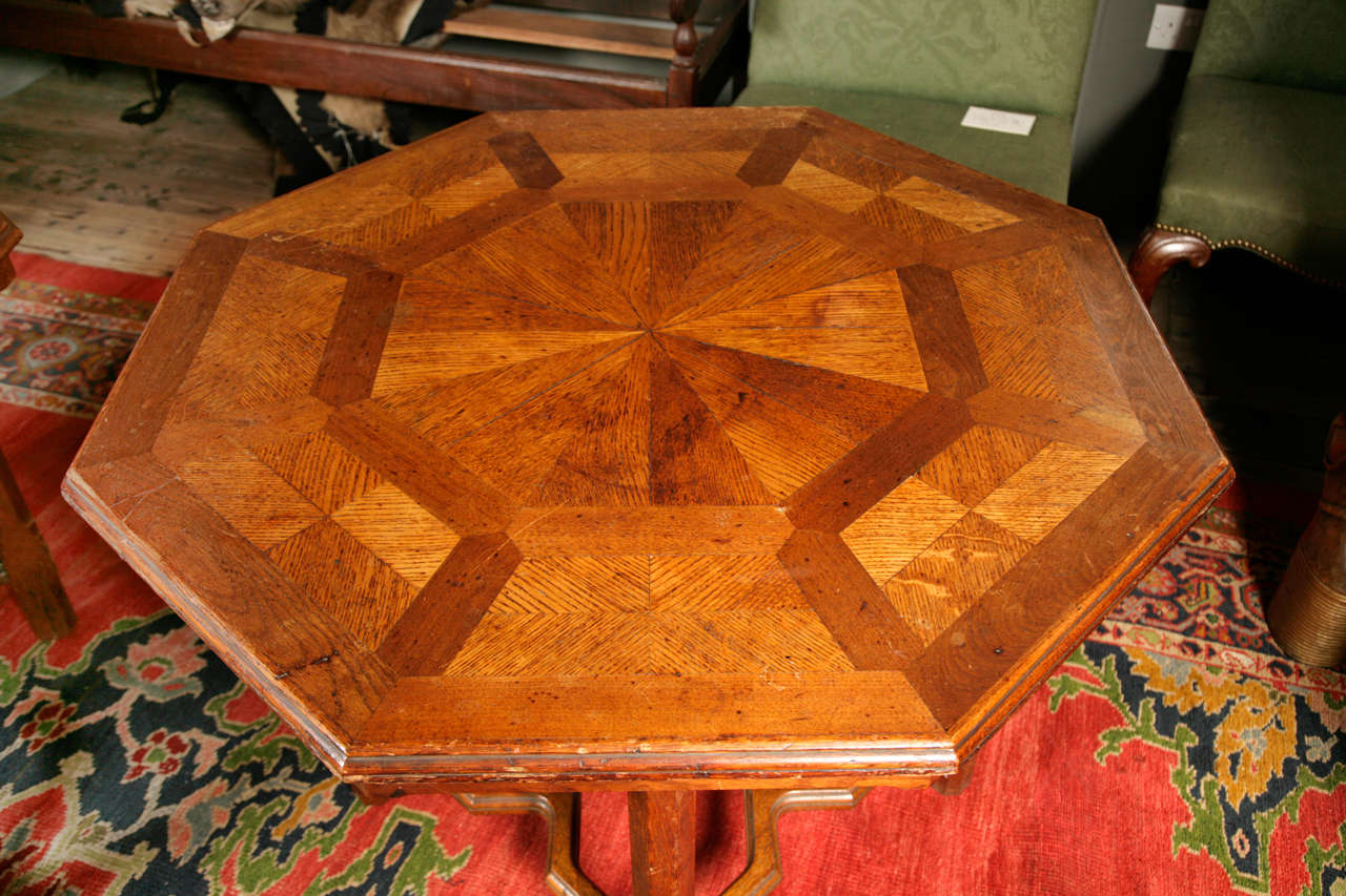 A pair of late 19th century octagonal oak parquetry decorated tables by
Howard & Sons of London on squared chamfered legs united by
stretchers.