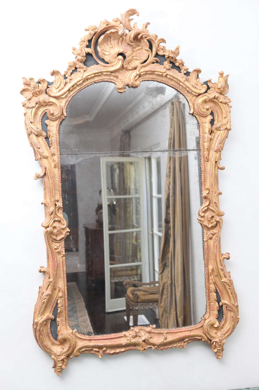 18th century French Regence mirror with finely carved giltwood and original plates.